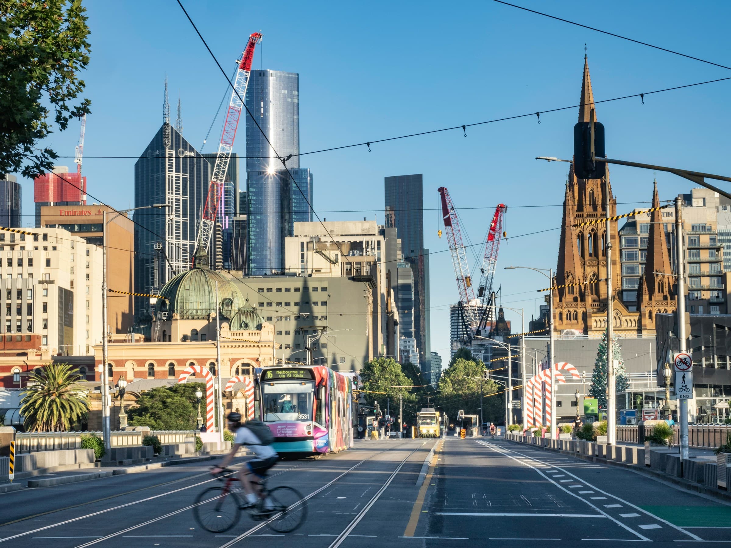 Melbourne city skyline with a tram crossing the bridge at golden hour
